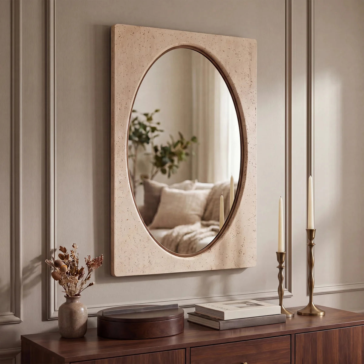 Adeline Faux Travertine Wall Mirror styled above a dark wood console in a warm neutral interior.