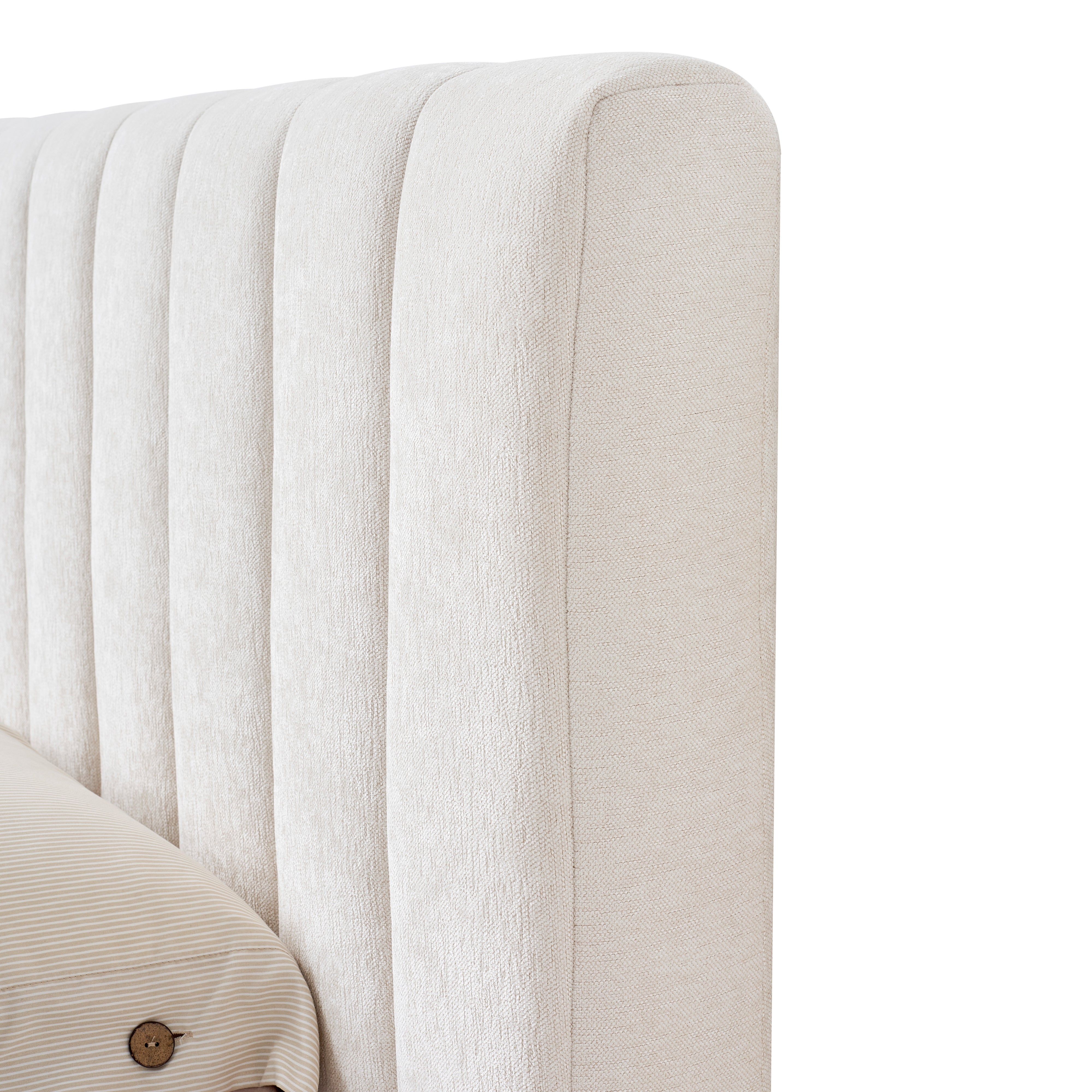 Close-up of a tufted beige linen headboard on a white background