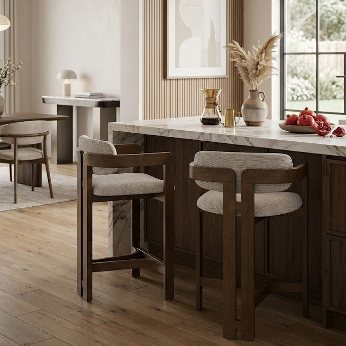 Modern kitchen with marble island, ash wooden counter stools, and decorative elements.
