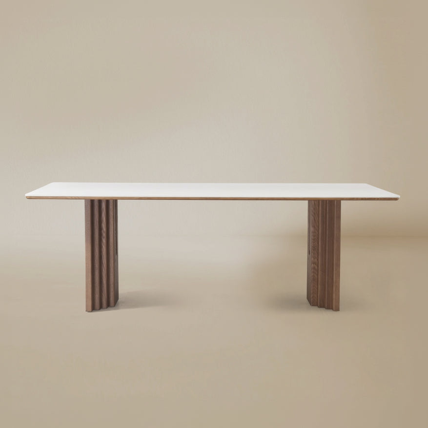 Arcadian Dining Table with a white travertine top and walnut wooden legs on a beige background