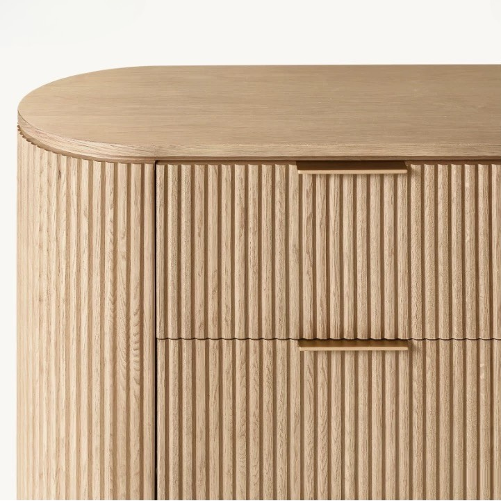 Macro detail of the Arden dresser showing the minimalist brass finger pull handles and precision-milled vertical wood fluting