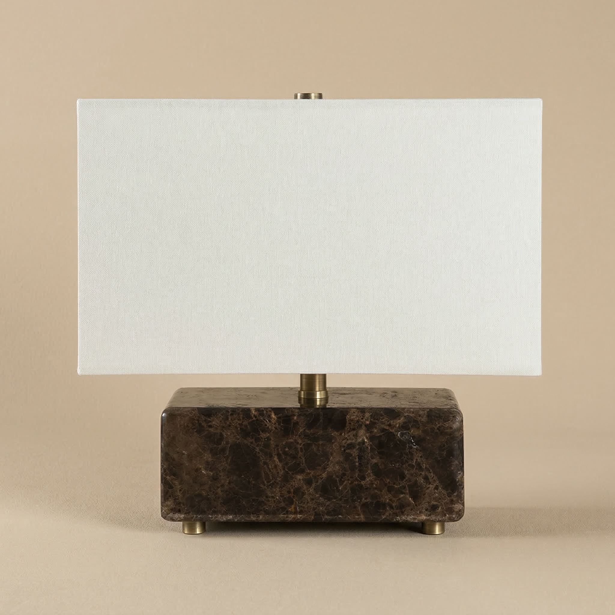 Table lamp with a Emperador marble base and white shade on a beige background