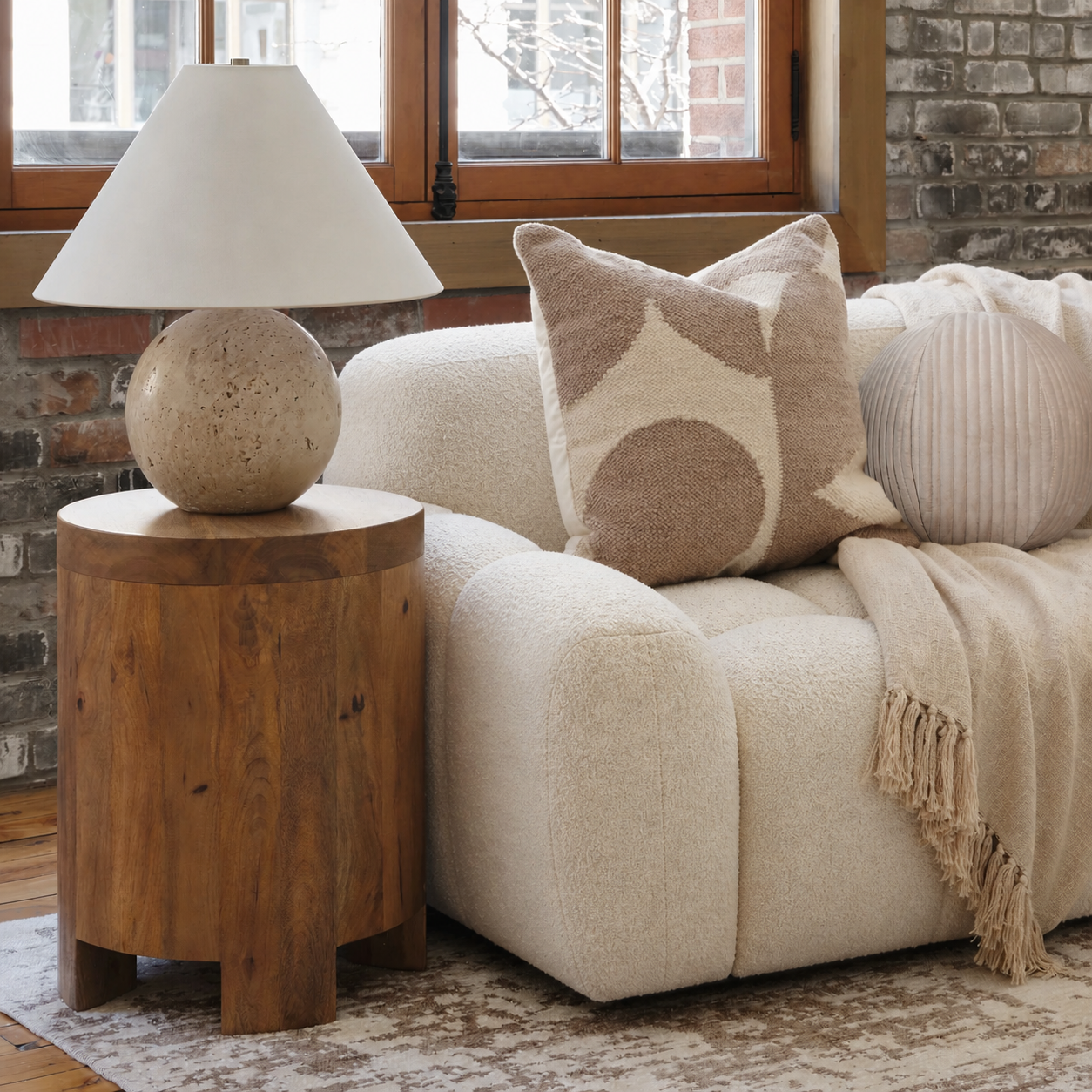 Cozy living room with a beige sofa, wooden side table, and decorative pillows.