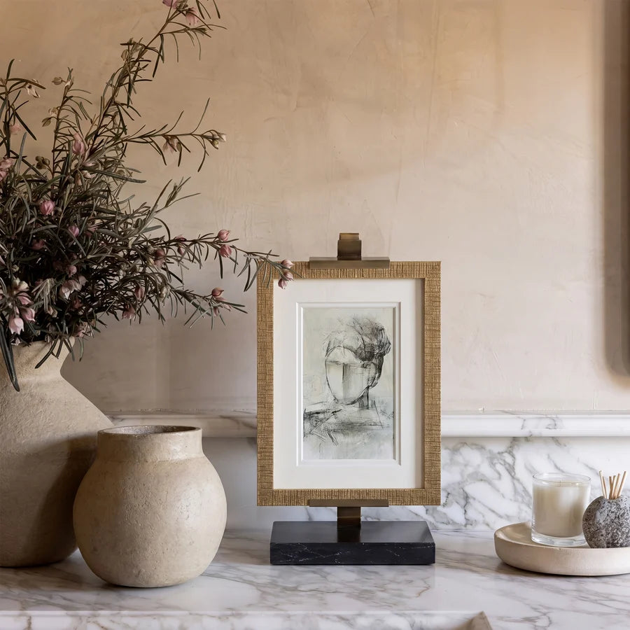 Arvessa marble and brass display easel holding framed artwork on a console