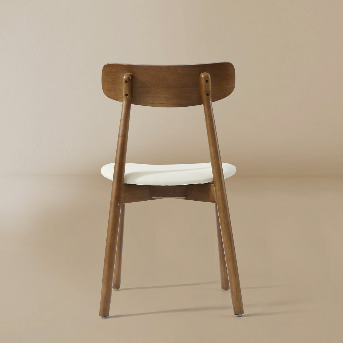 Back profile of the Ash Classic dining chair featuring a solid wood frame with a dark walnut finish, curved backrest, and cream upholstered seat