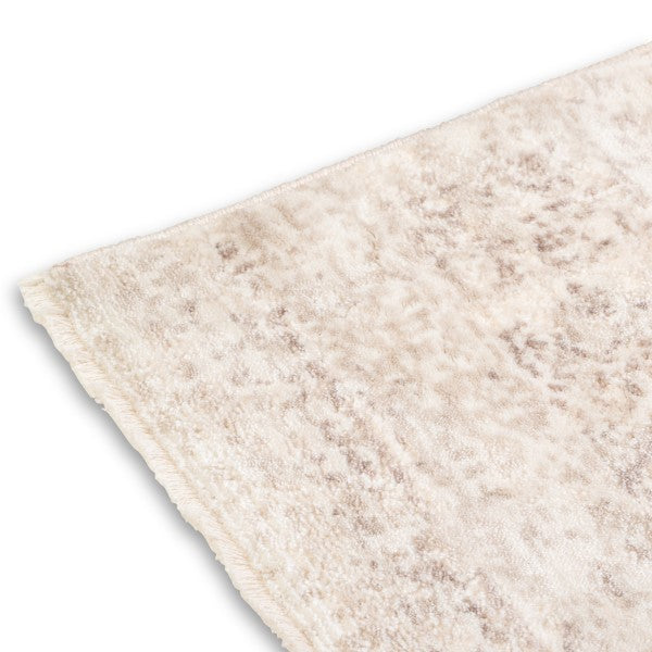 A detailed view of the corner and delicate short fringe on the Audrey traditional neutral rug.