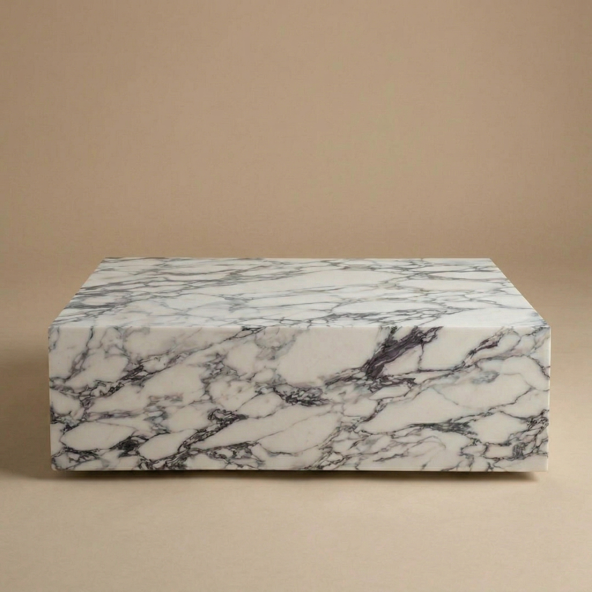 White and grey veined sintered stone plinth coffee table with a monolithic block design.