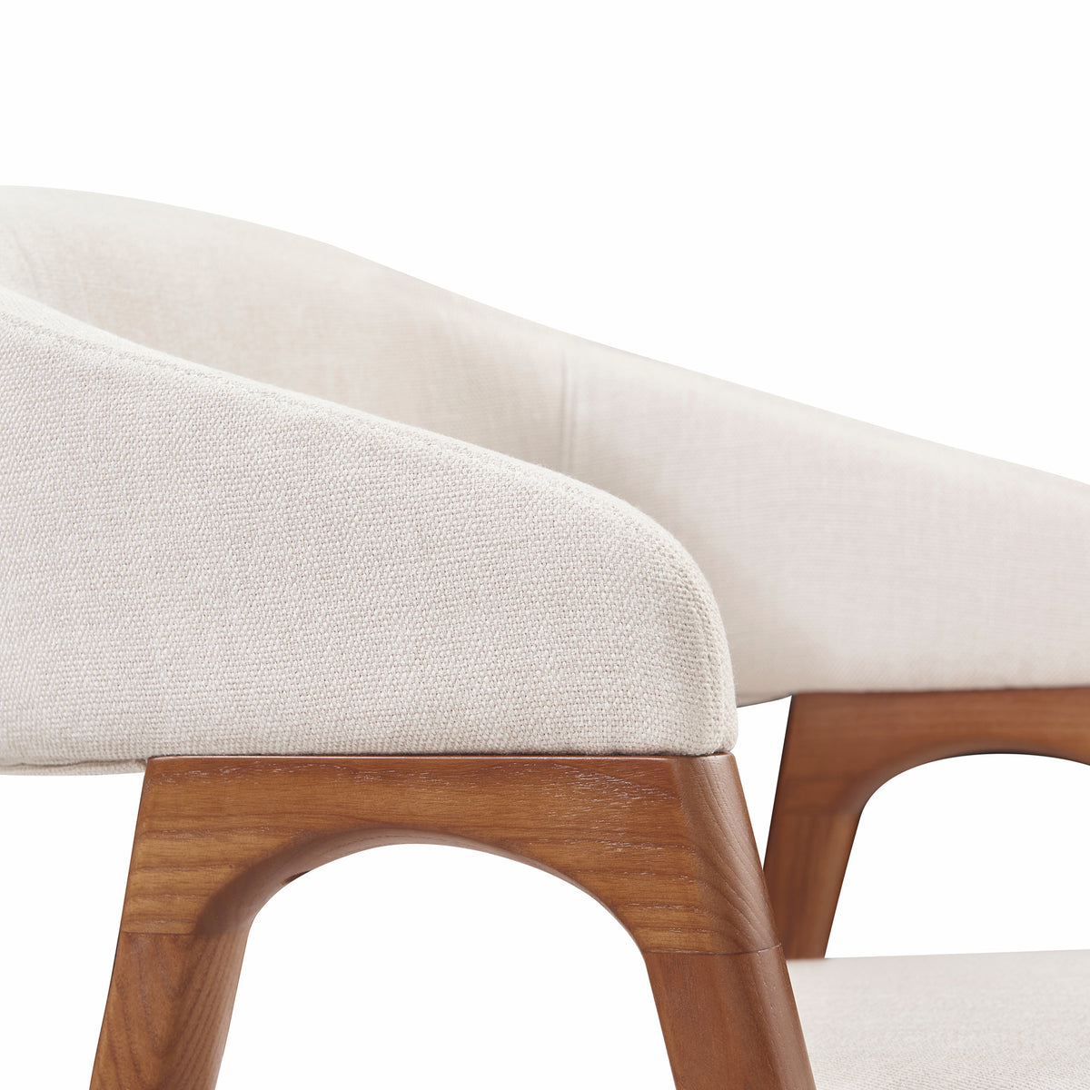 Close-up of the Calira dining chair’s linen upholstered arm and arched ash wood veneer side frame