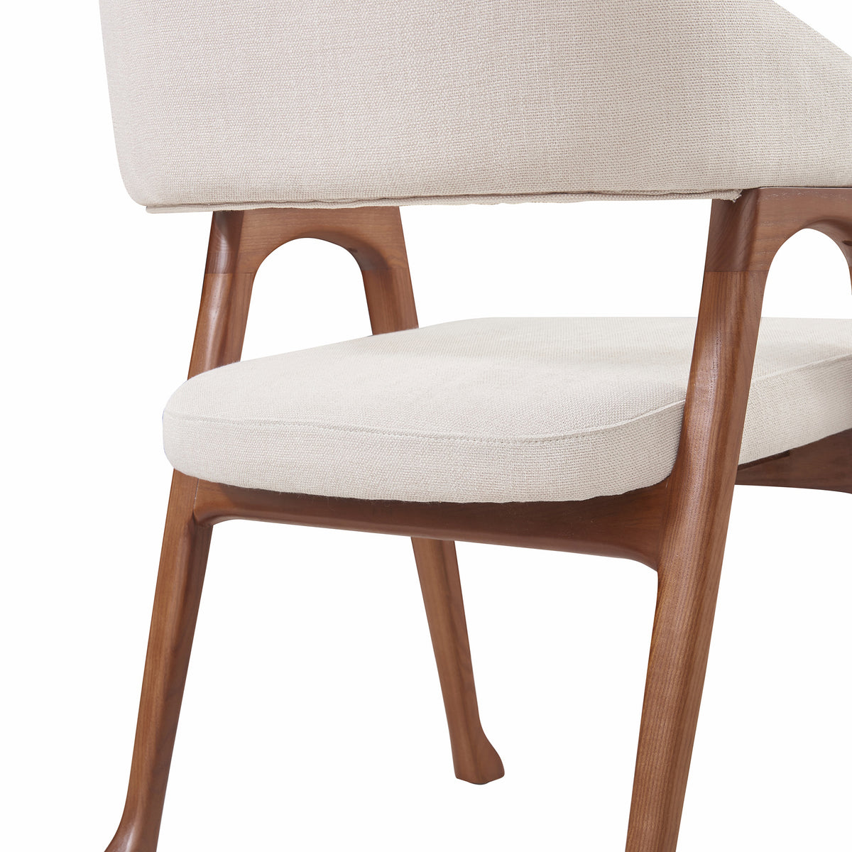 Close-up of the Calira linen dining chair showing its padded seat, wood frame and flared leg detail