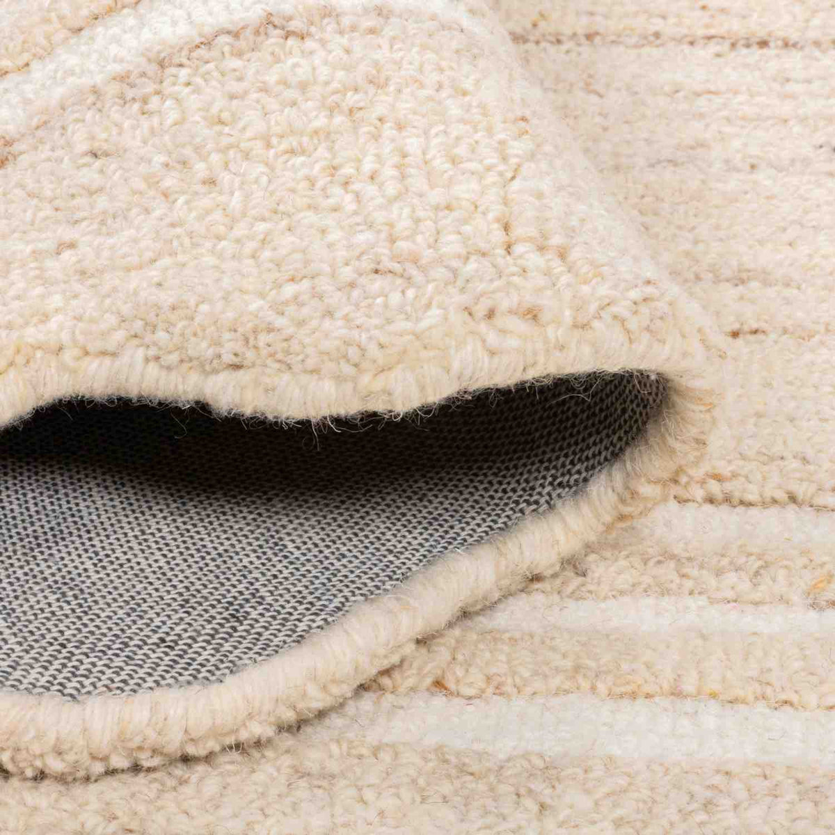 Close-up of the Camille Hand-Tufted Wool Rug showing the plush looped wool pile and woven underside.