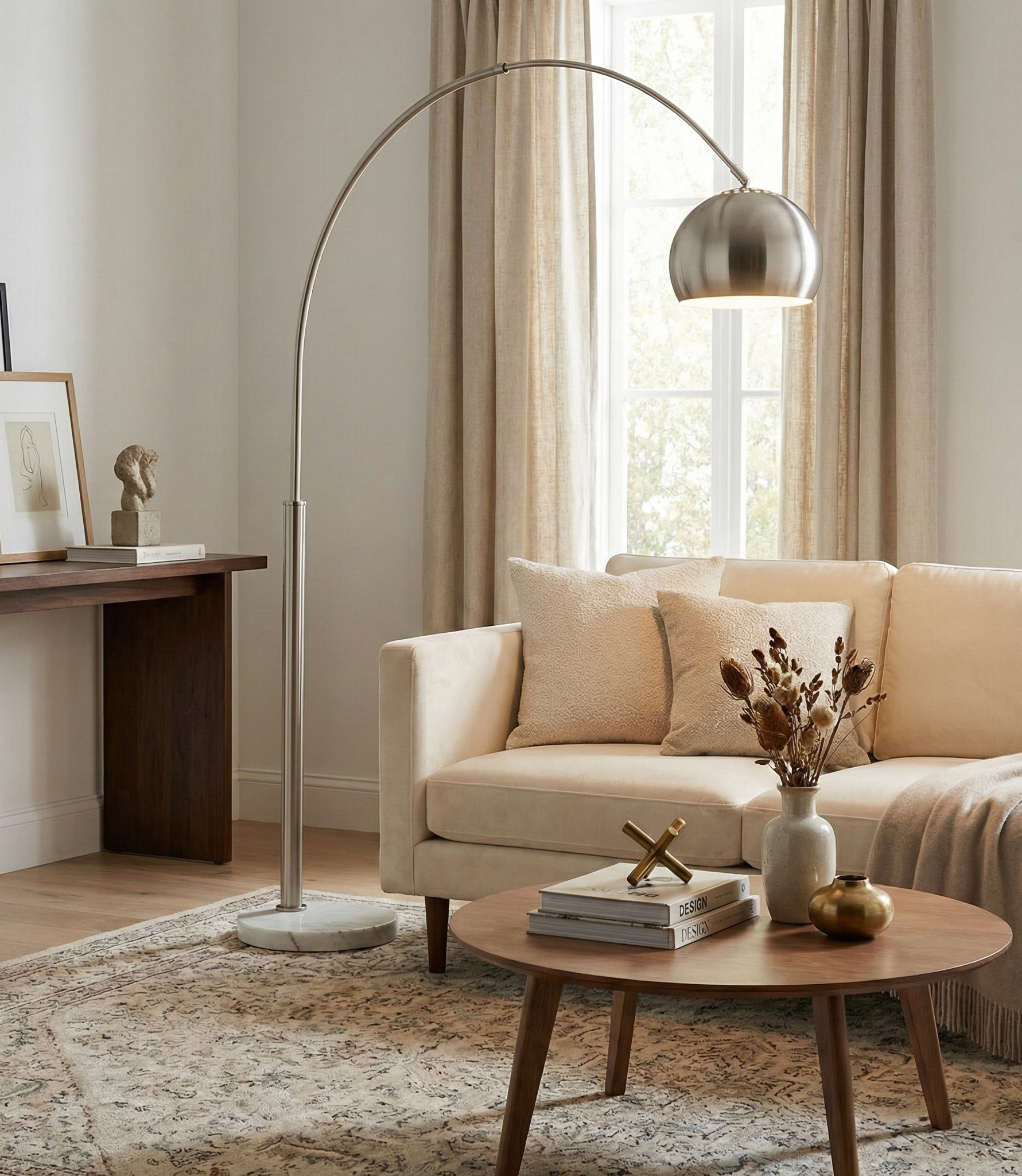 Cassia chrome arc floor lamp styled in a bright modern living room, providing overhead lighting for a sectional sofa.