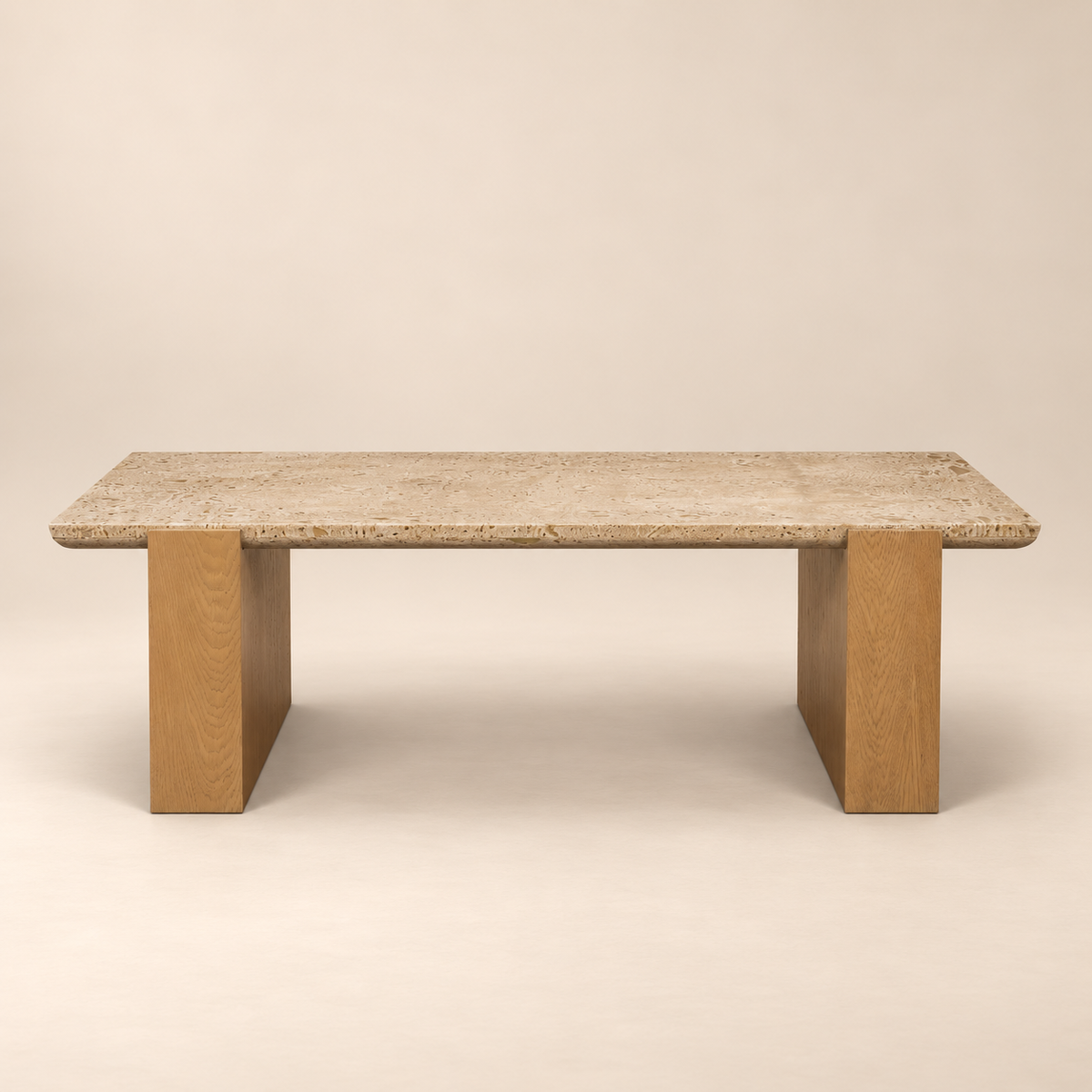 Front studio view of the Cavelle Travertine & Oak Coffee Table with a rectangular beige travertine top and light brown oak blade legs on a warm beige background.