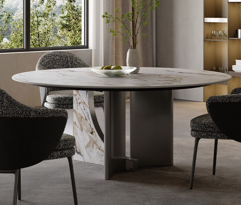 Celestia Elegance round dining table with marble-patterned sintered stone top and stainless steel base, styled with modern chairs beside a large window