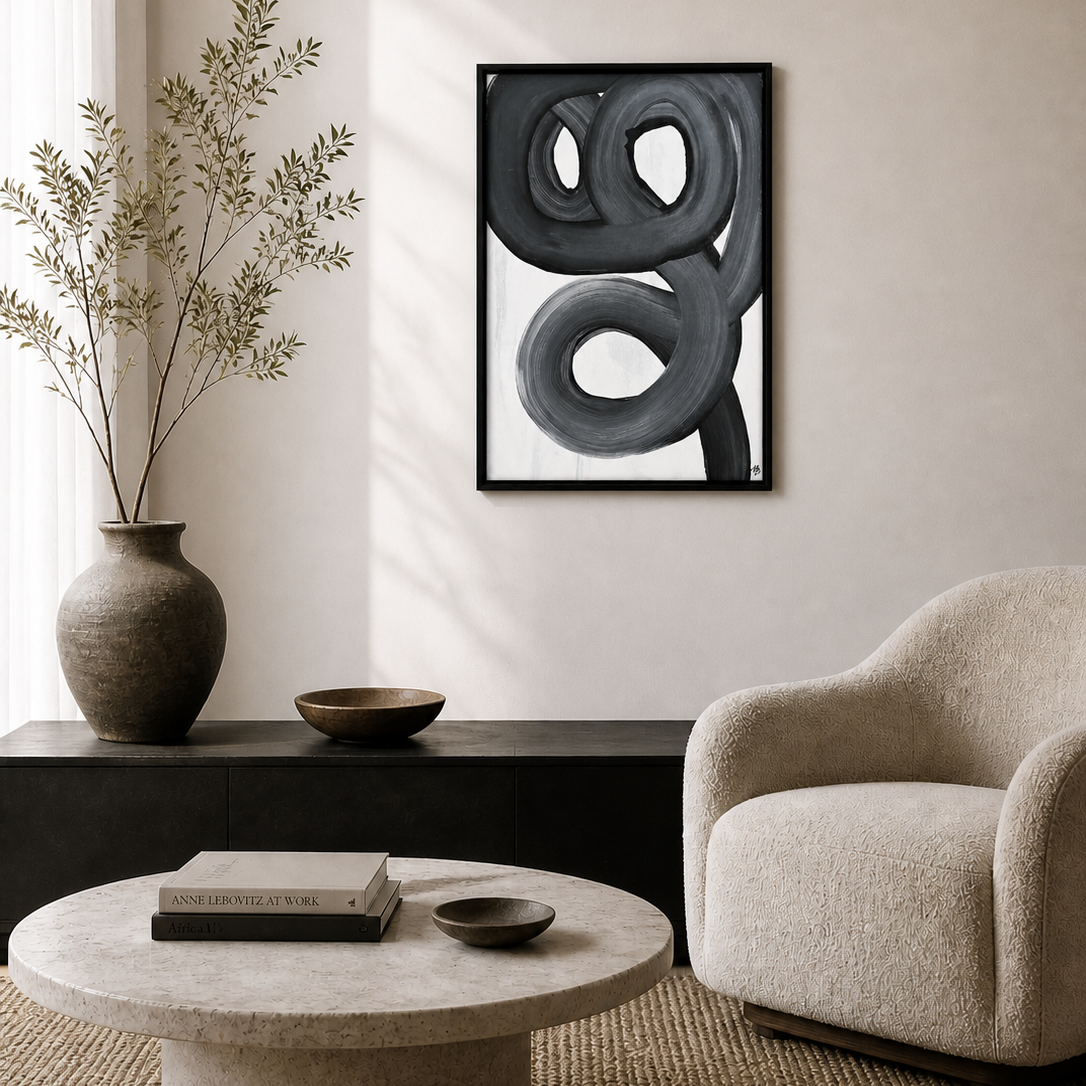 Modern living room with abstract art, vase, and armchair.