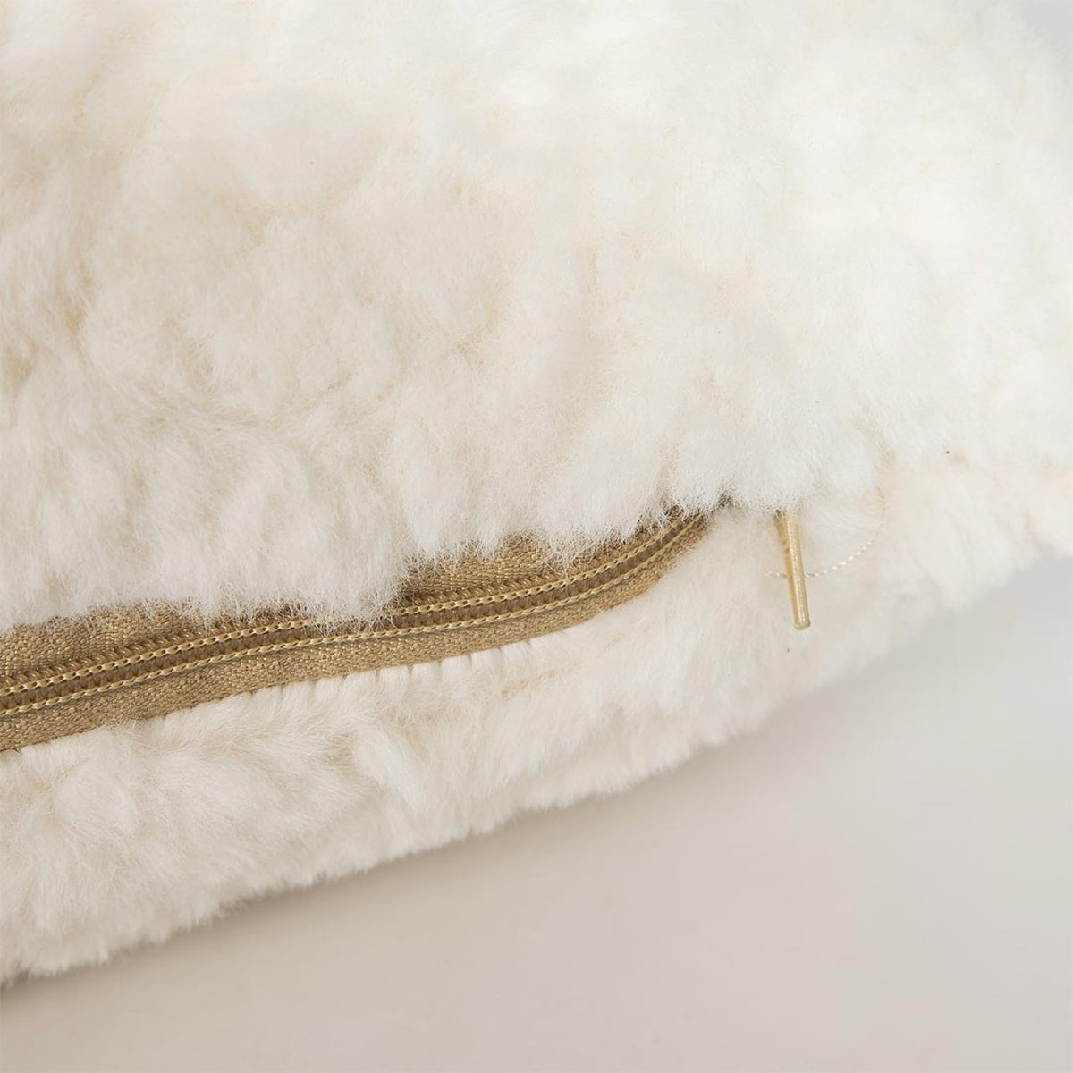 Close-up of the curly-pile lumbar pillow from the Cloudline set showing the hidden zipper and plush texture.