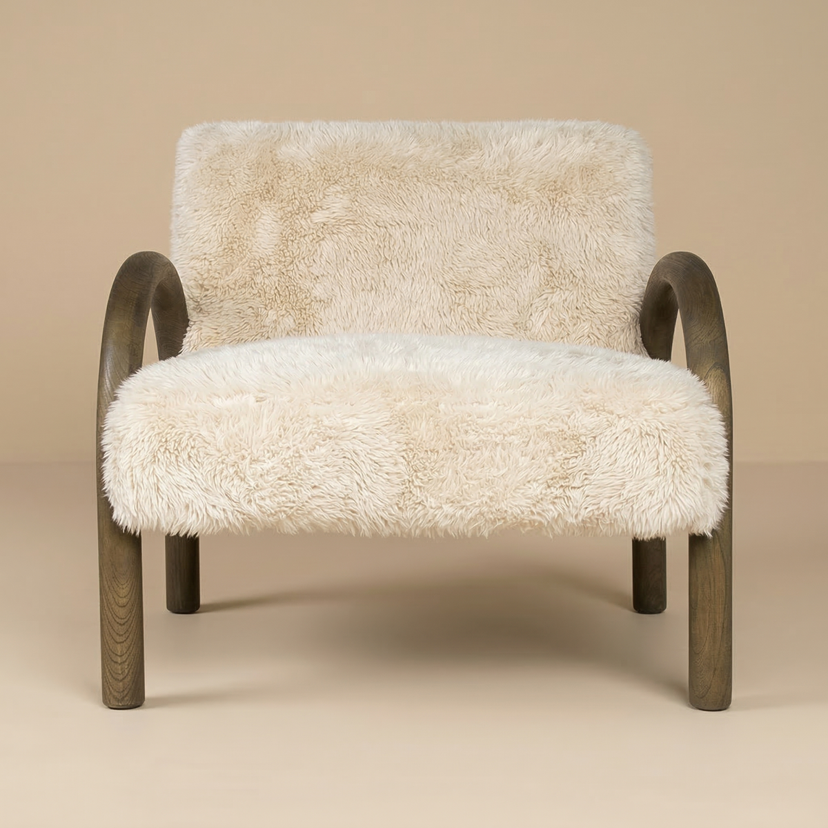 Full front view of the Coco accent chair featuring shaggy sand faux fur and arched dark wood arms.
