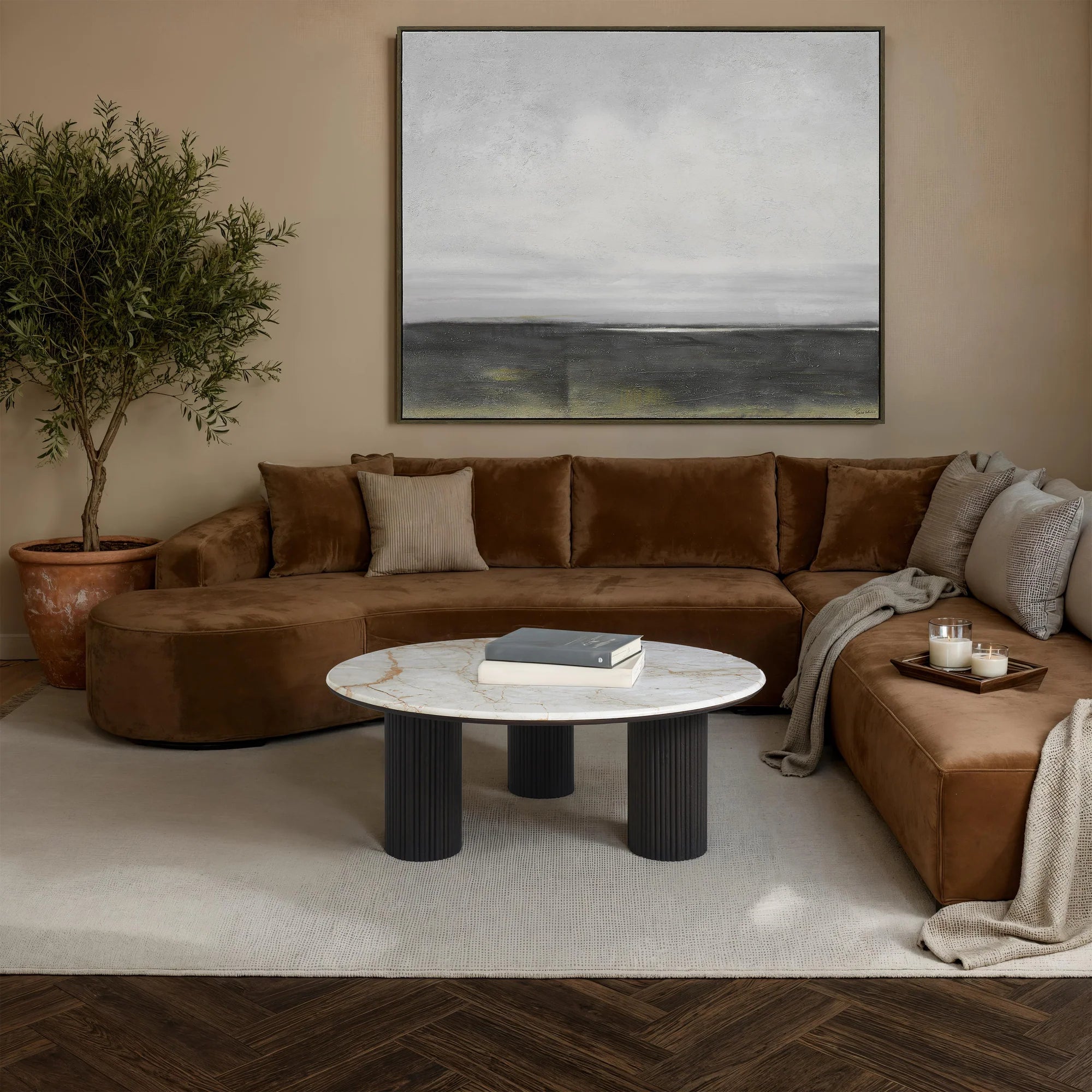 Modern living room with brown sectional sofa, marble coffee table, and abstract painting.