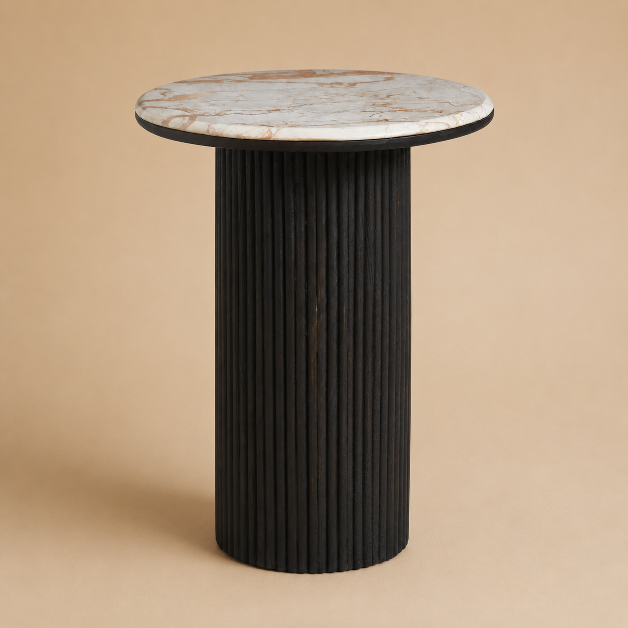 Round side table with marble top and ribbed black base on a beige background