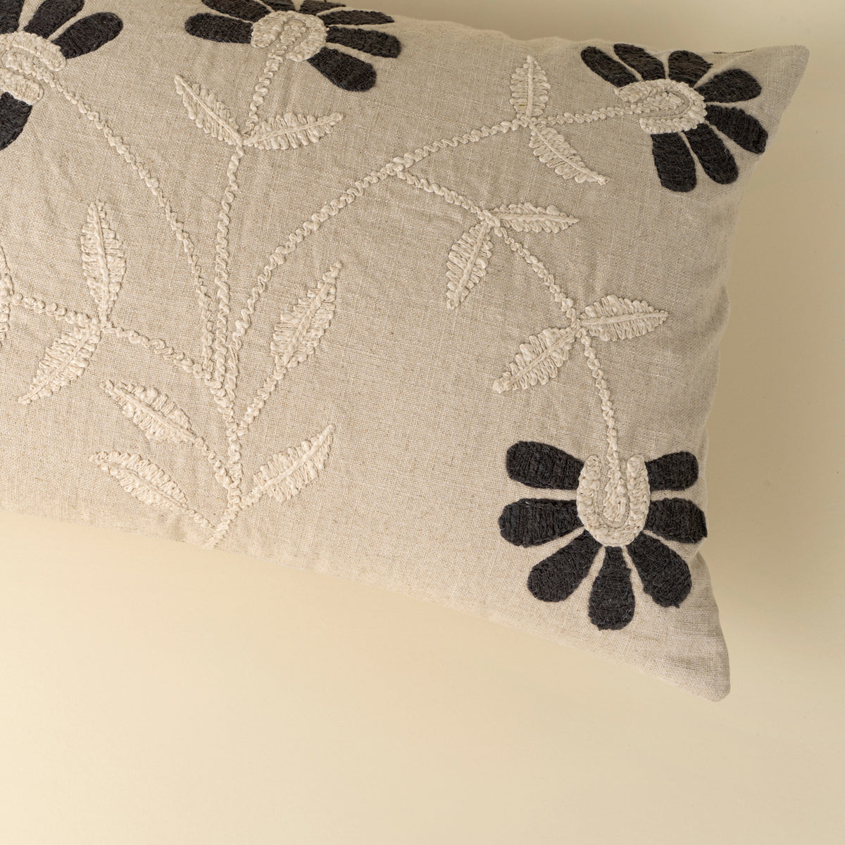 Decorative pillow with floral embroidery on a beige background