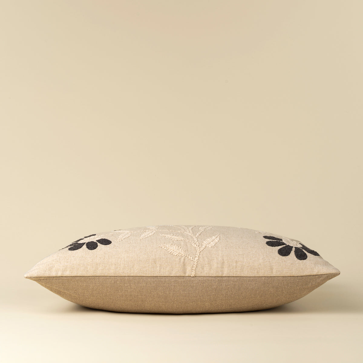 Decorative pillow with floral embroidery on a beige background