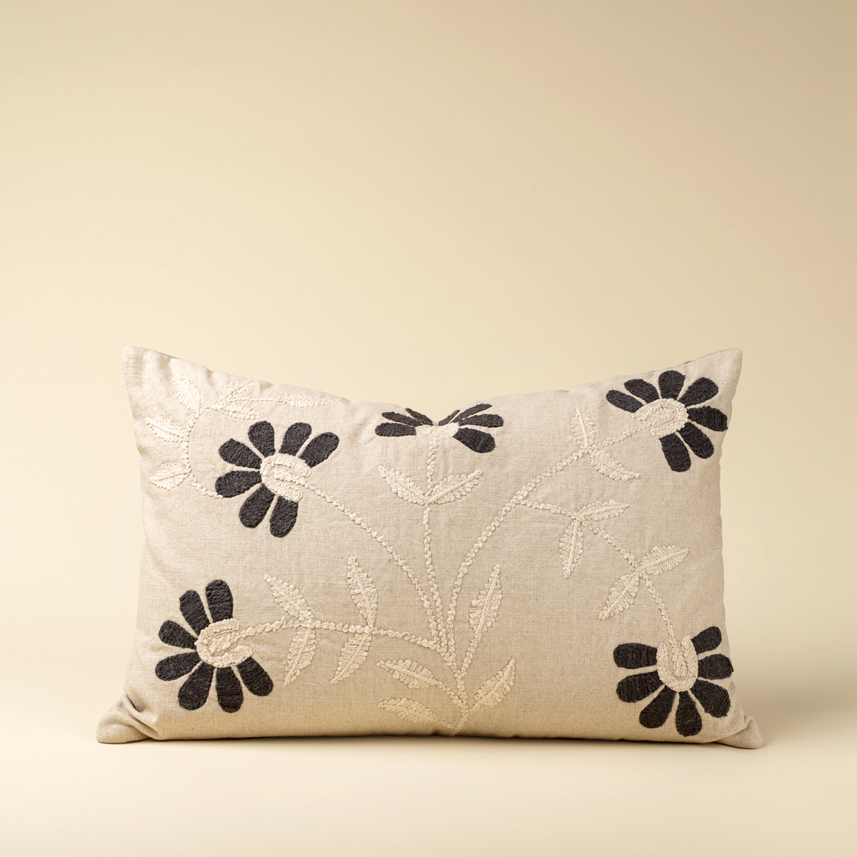 Decorative pillow with floral embroidery on a beige background