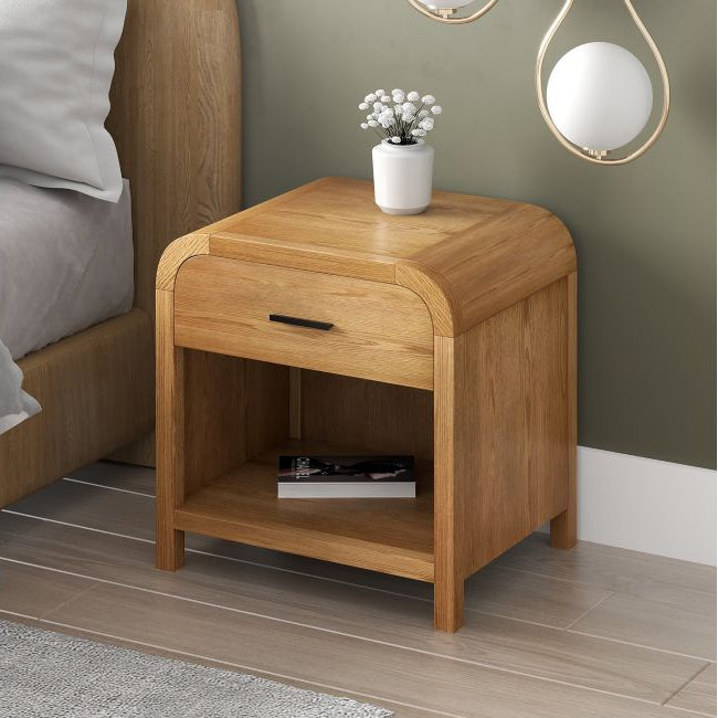 Natural oak Eamon Nightstand styled beside a wood bed with a small vase
