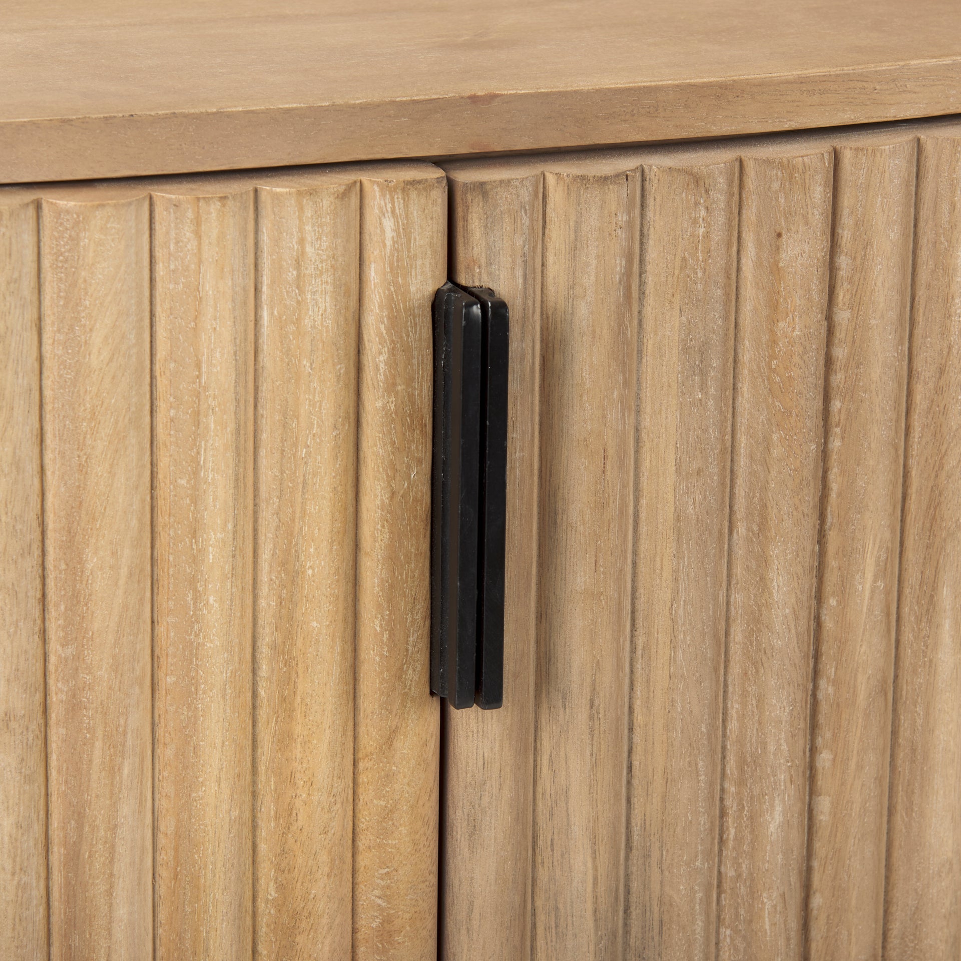 Macro detail of the textured fluted doors and matte black vertical hardware on the light wood Eleanor cabinet.