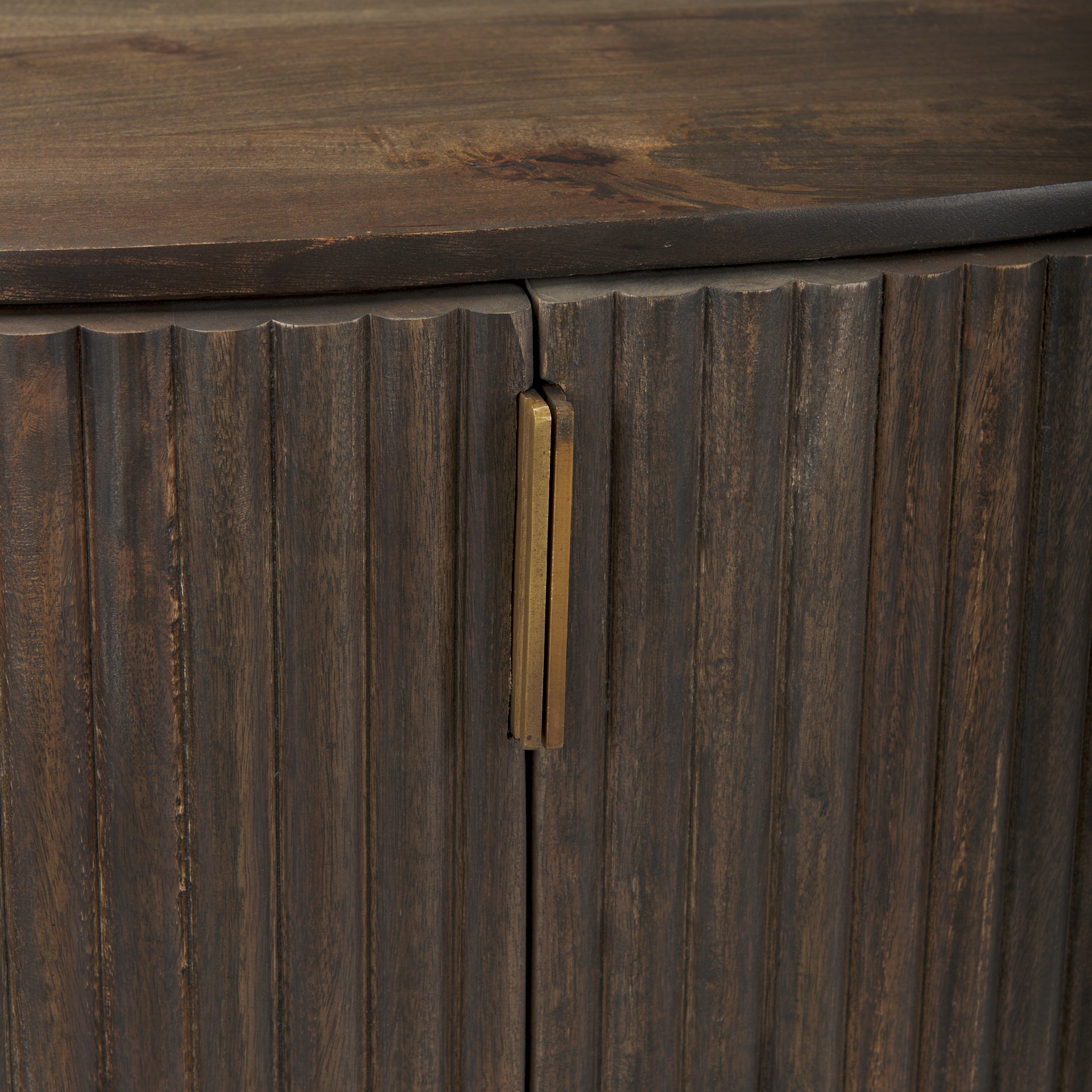 Macro detail of the textured fluted doors and vertical brass hardware on the dark wood Eleanor cabinet.