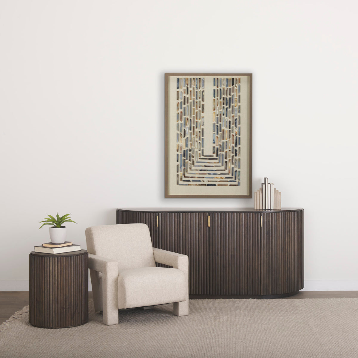 The Eleanor dark mango wood fluted side table styled next to a cream armchair and matching dark wood sideboard.
