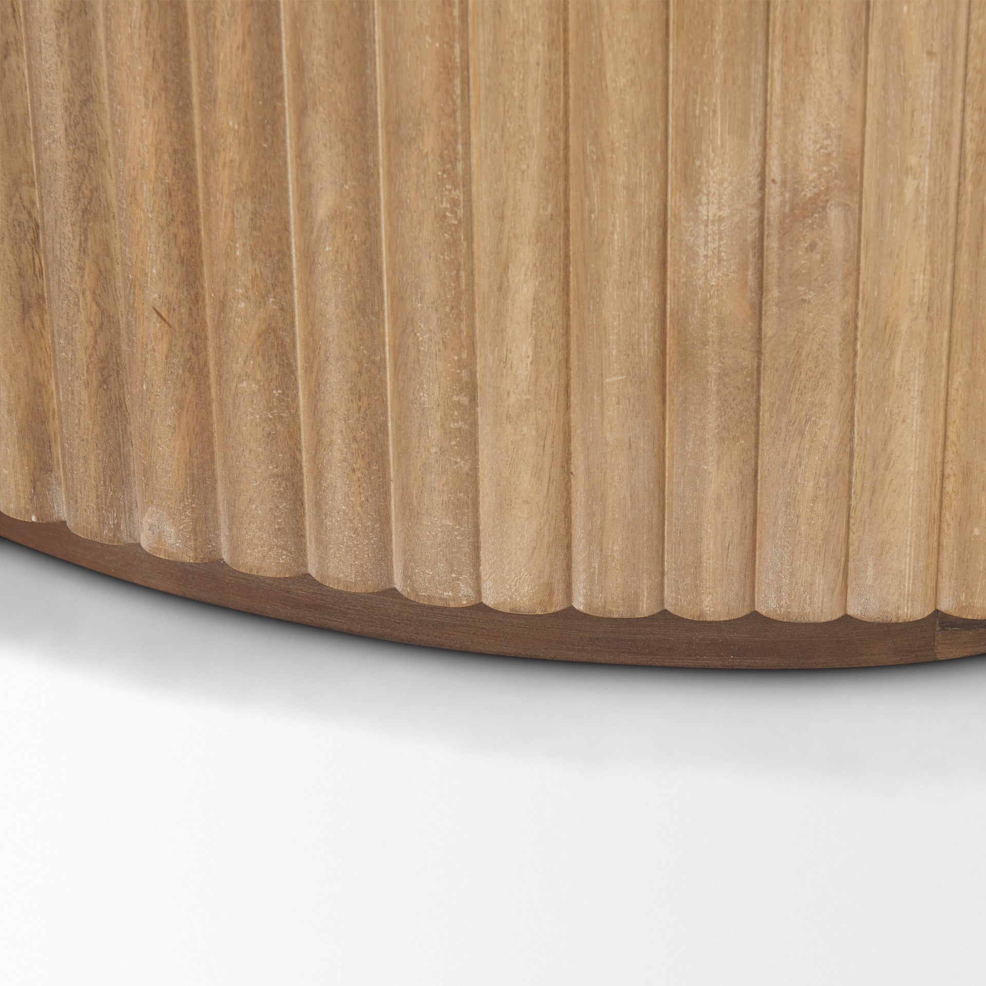 Close-up of the curved bottom edge and vertical fluted wood detailing on the light natural Eleanor accent cabinet.