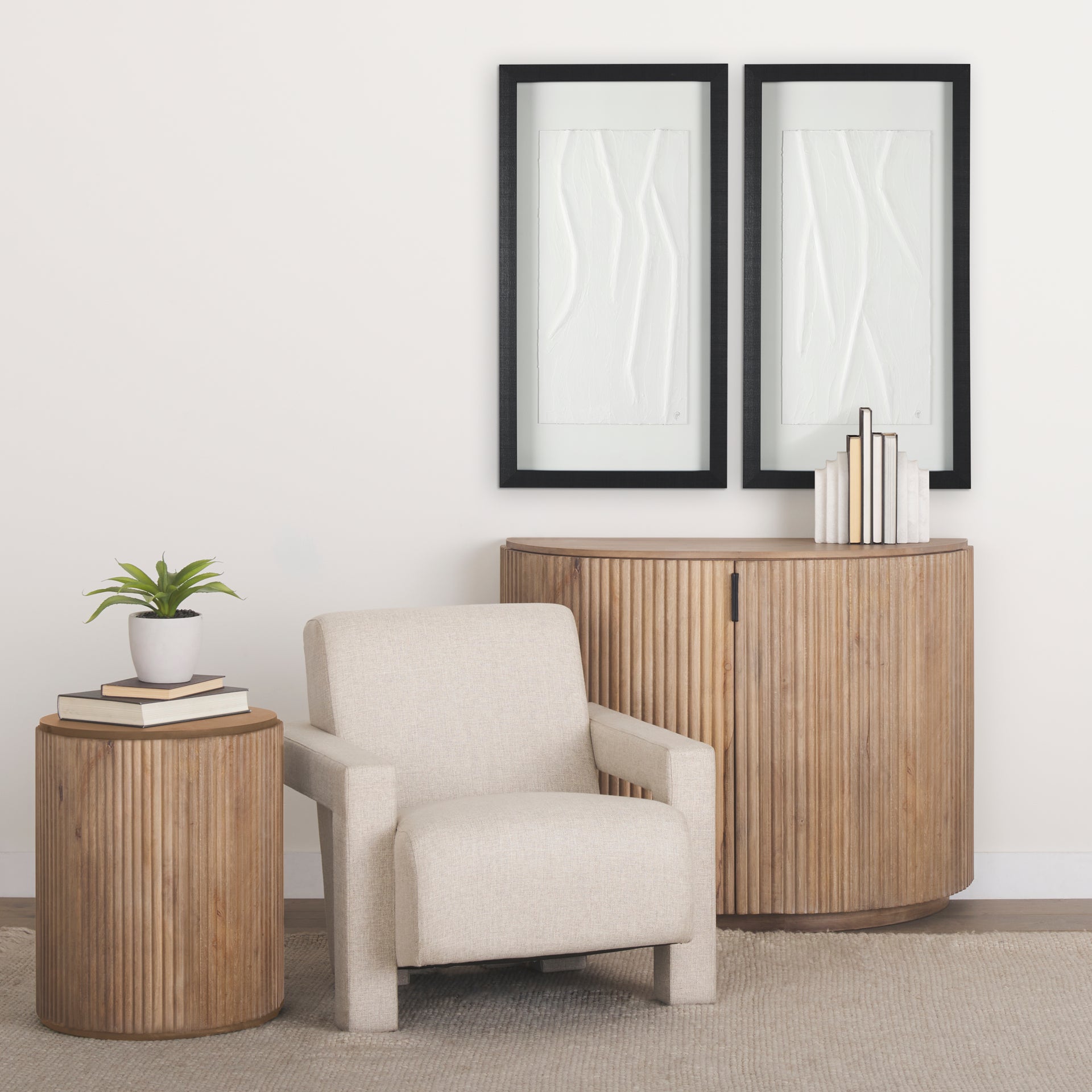 The Eleanor light wood fluted accent cabinet styled in a bright living room next to a cream armchair and potted plant.