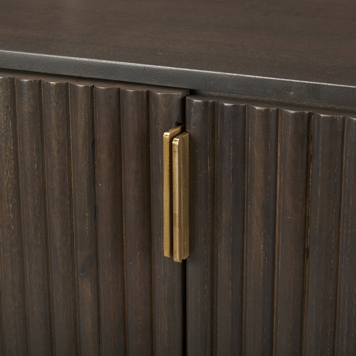 Macro detail of the textured fluted wood doors and vertical brass handles on the Eleanor sideboard