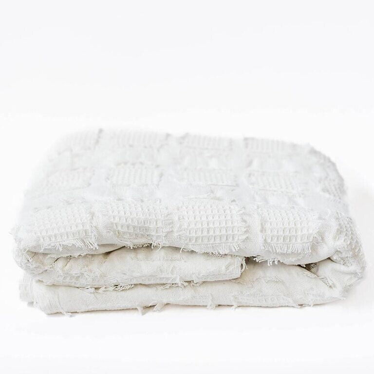 Stack of white textured towels on a white background