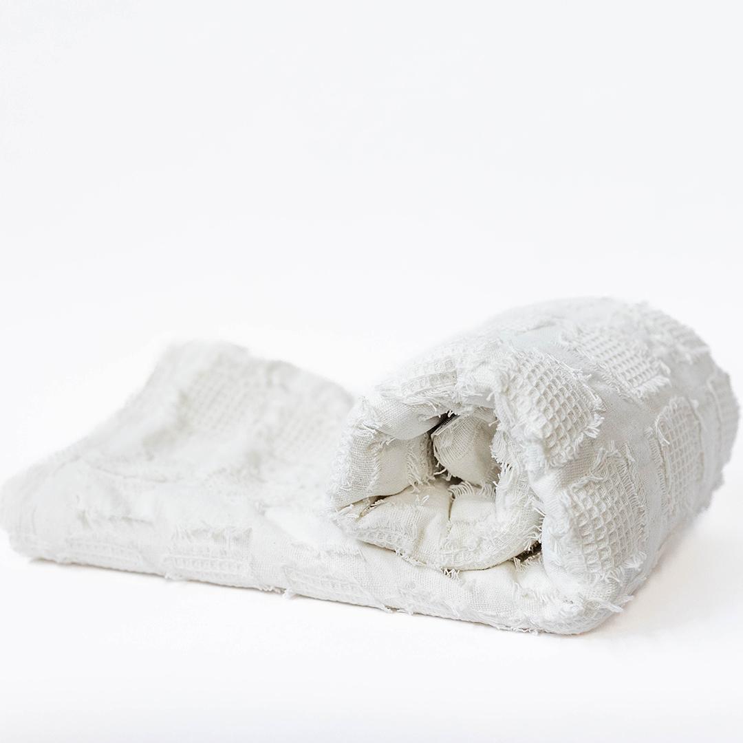Rolled-up white towel on a white background