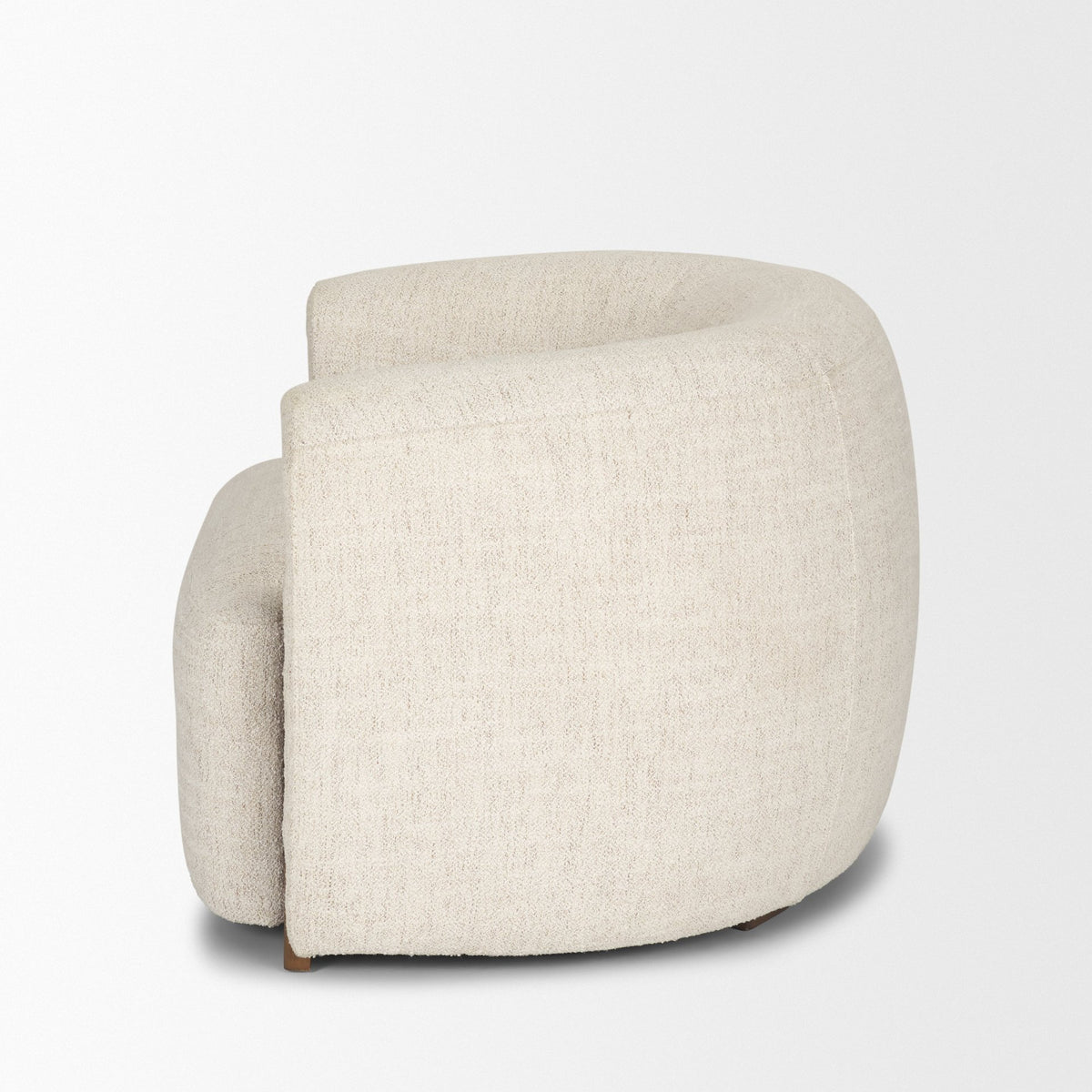 Side profile of the Elodie barrel chair against a plain white background, highlighting its low-profile and curved backrest.