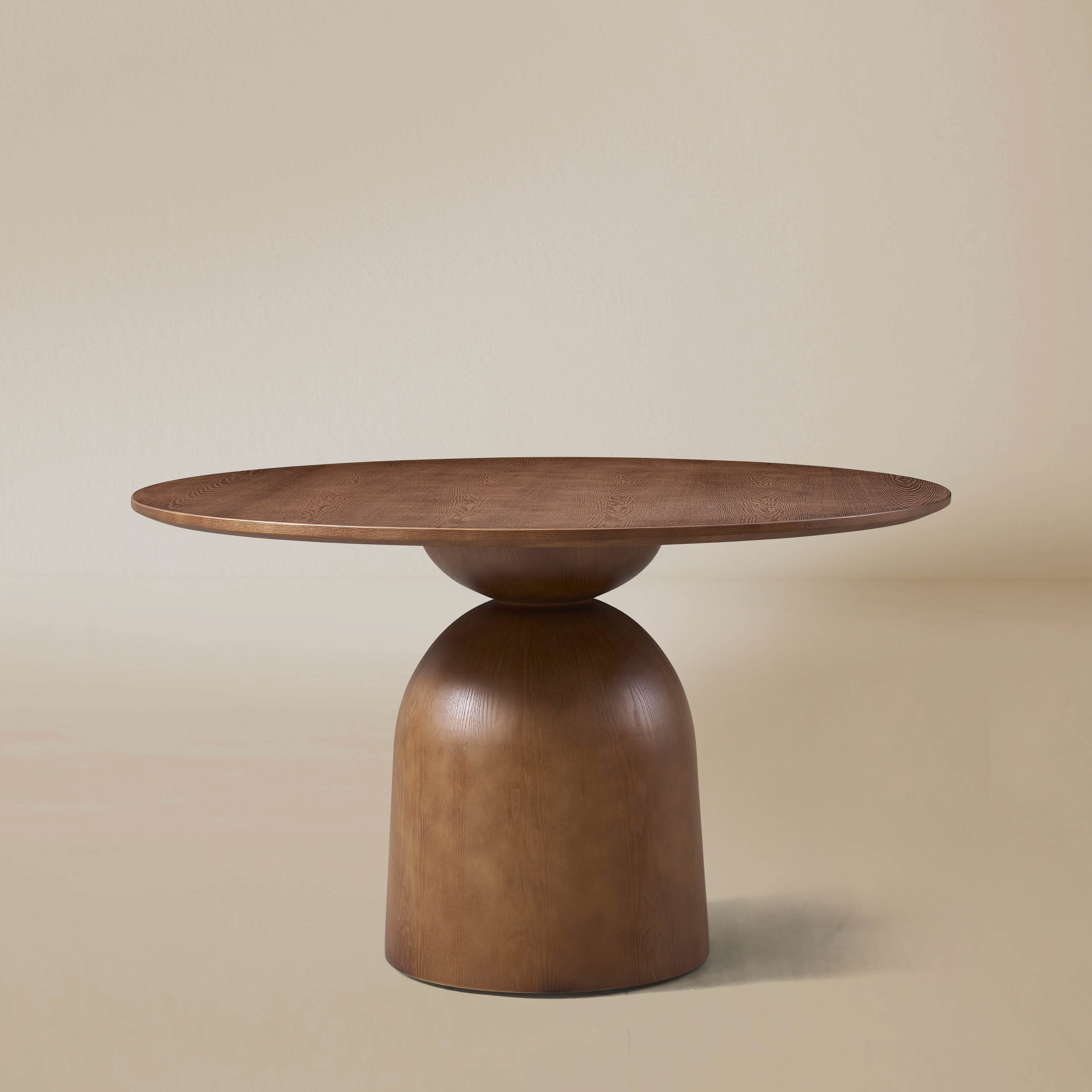 Evelyn round dining table in walnut-finished ash wood veneer.