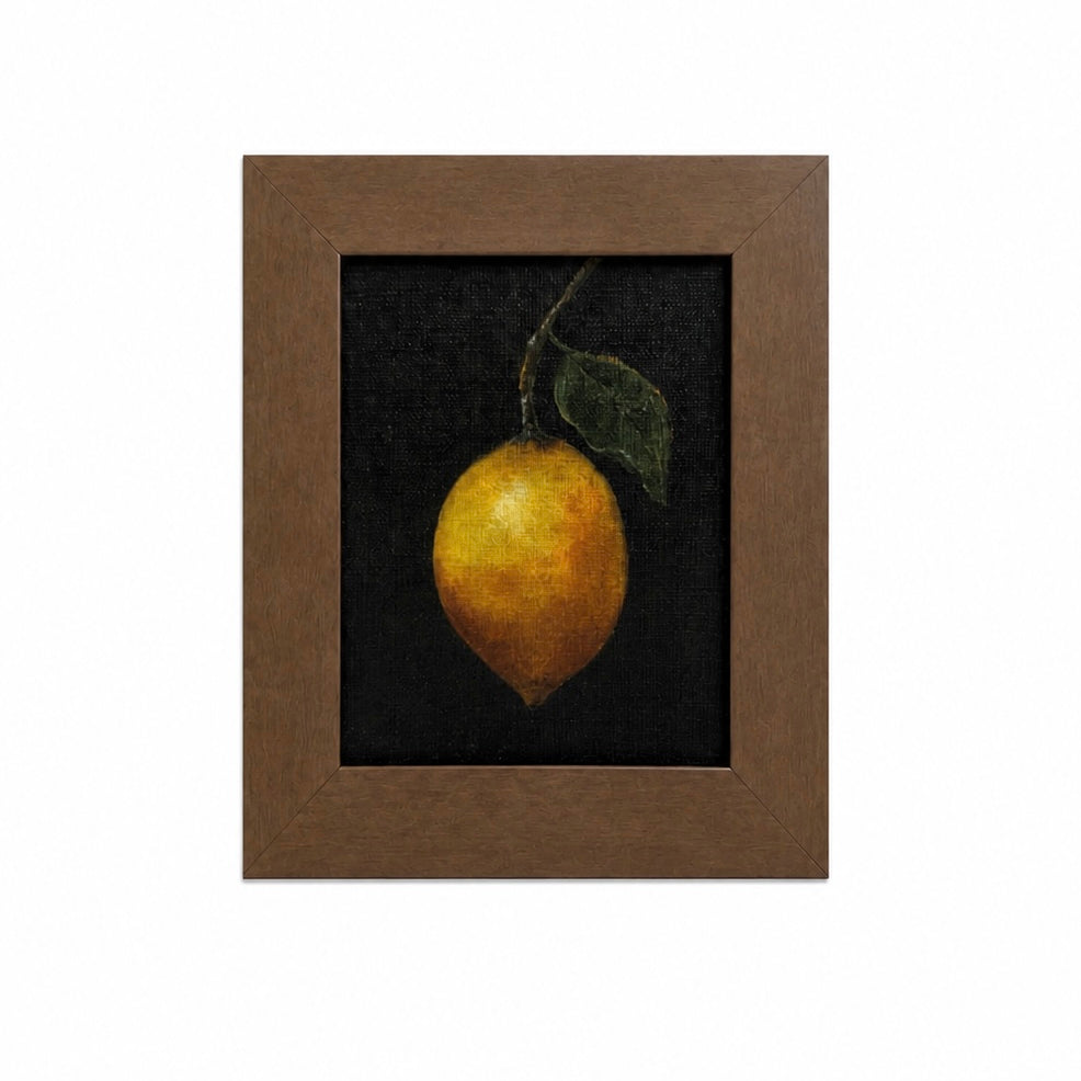 Framed artwork of a lemon with a leaf on a dark background