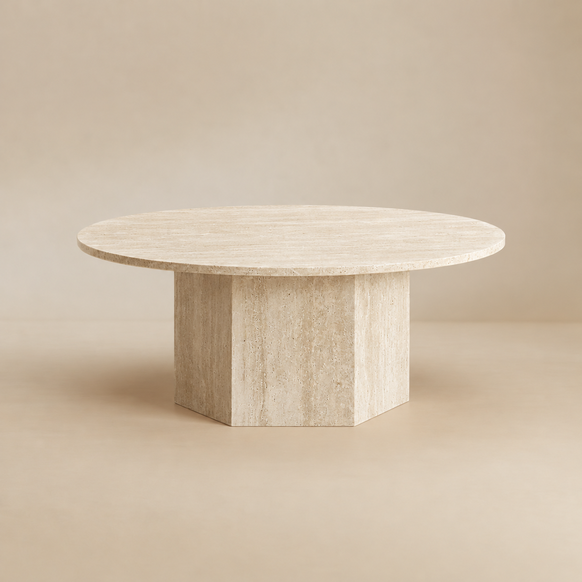 Harmony round travertine coffee table featuring a smooth honed top and a structural hexagonal pedestal base.