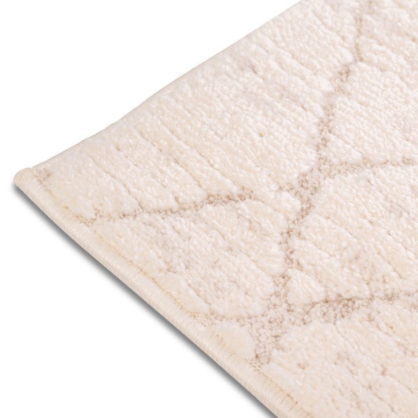 Close-up of the bound edge and textured high-low pile on the cream and beige Harper modern trellis rug.