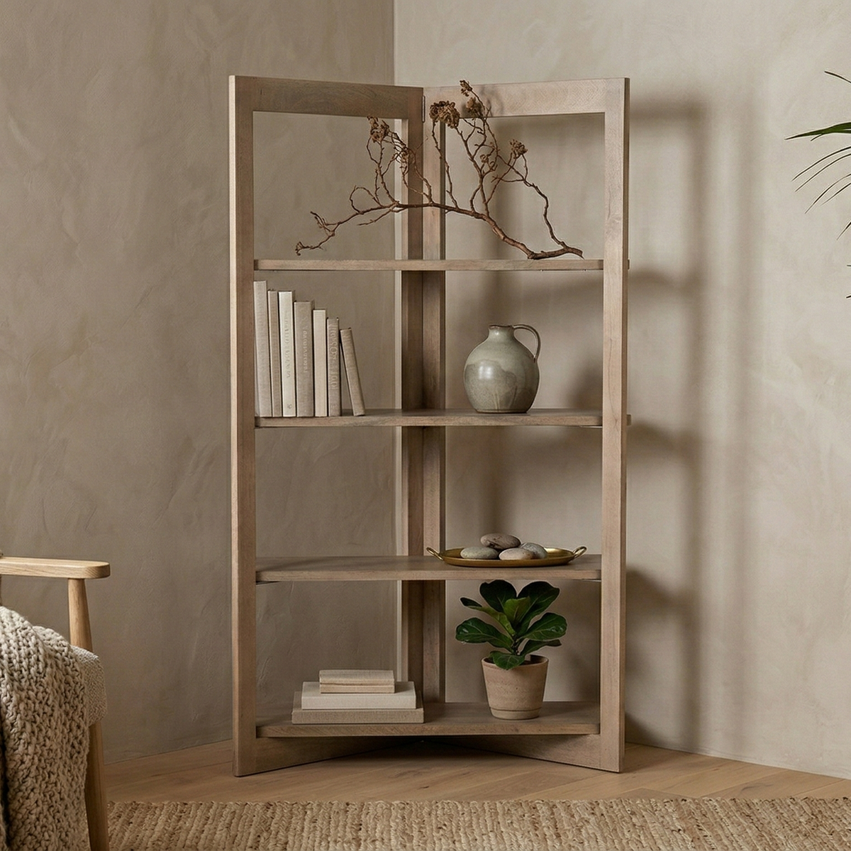 The Kade geometric shelving unit styled in a cozy living room corner with books and decor, next to a textured armchair.