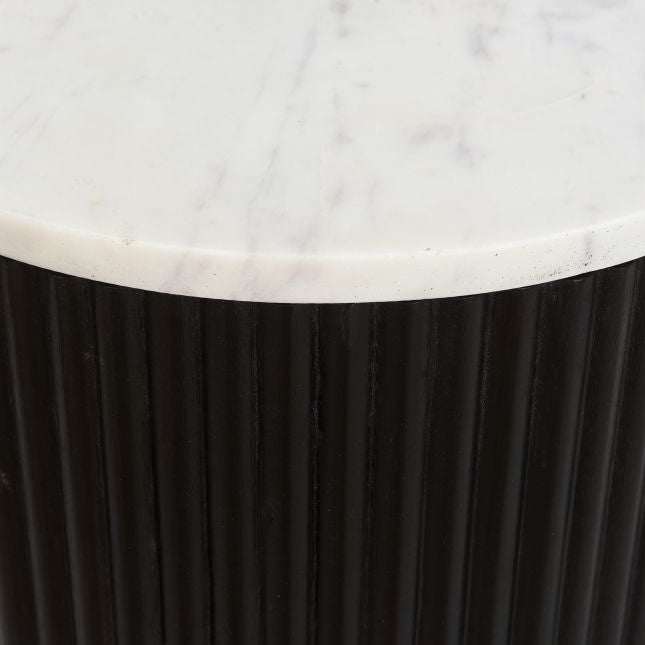 Round side table with marble top and black base on a white background