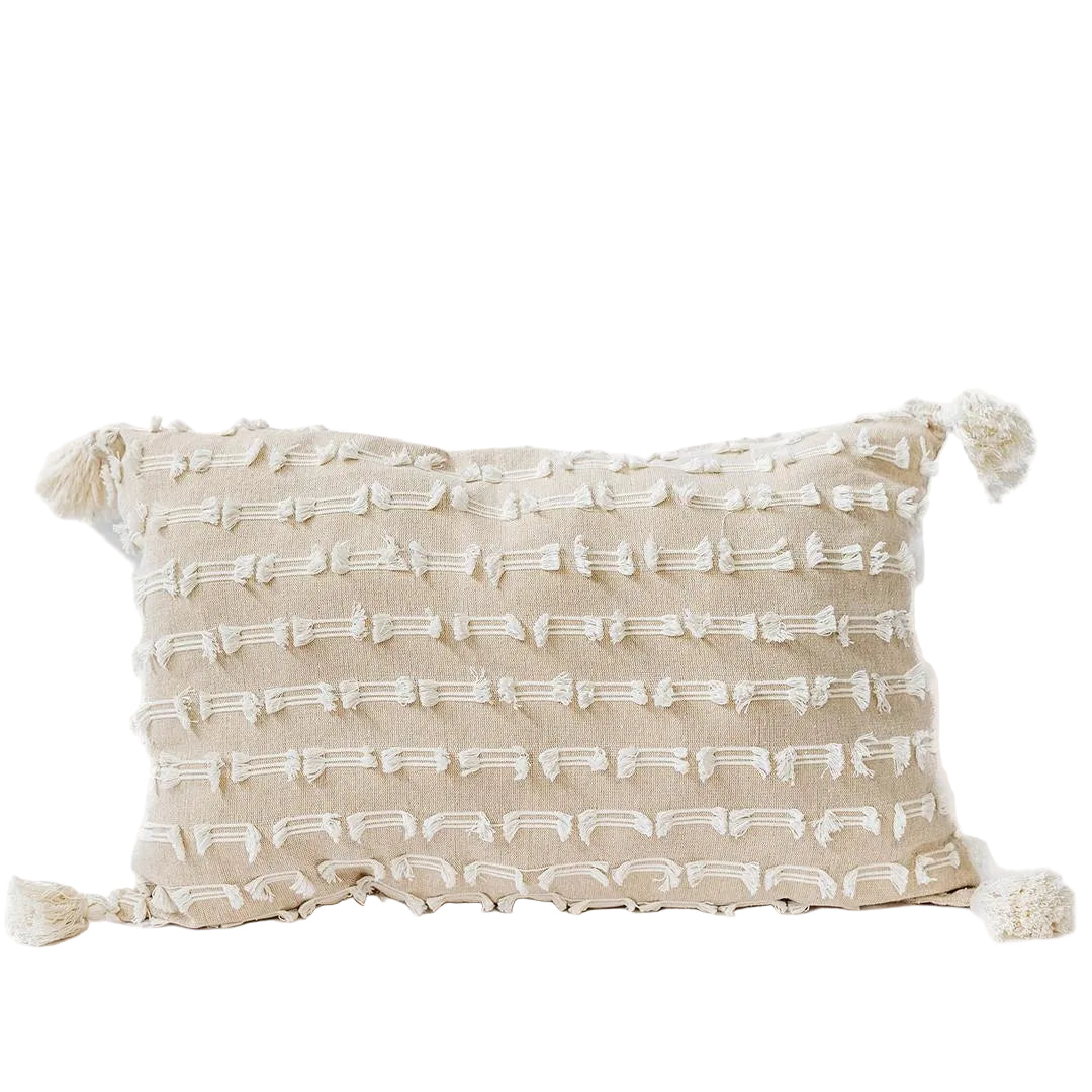 Beige pillow with white pattern and tassels on a white background