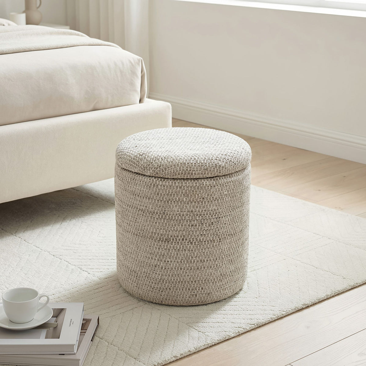 Round woven storage ottoman in a living room setting with a sofa and coffee table.