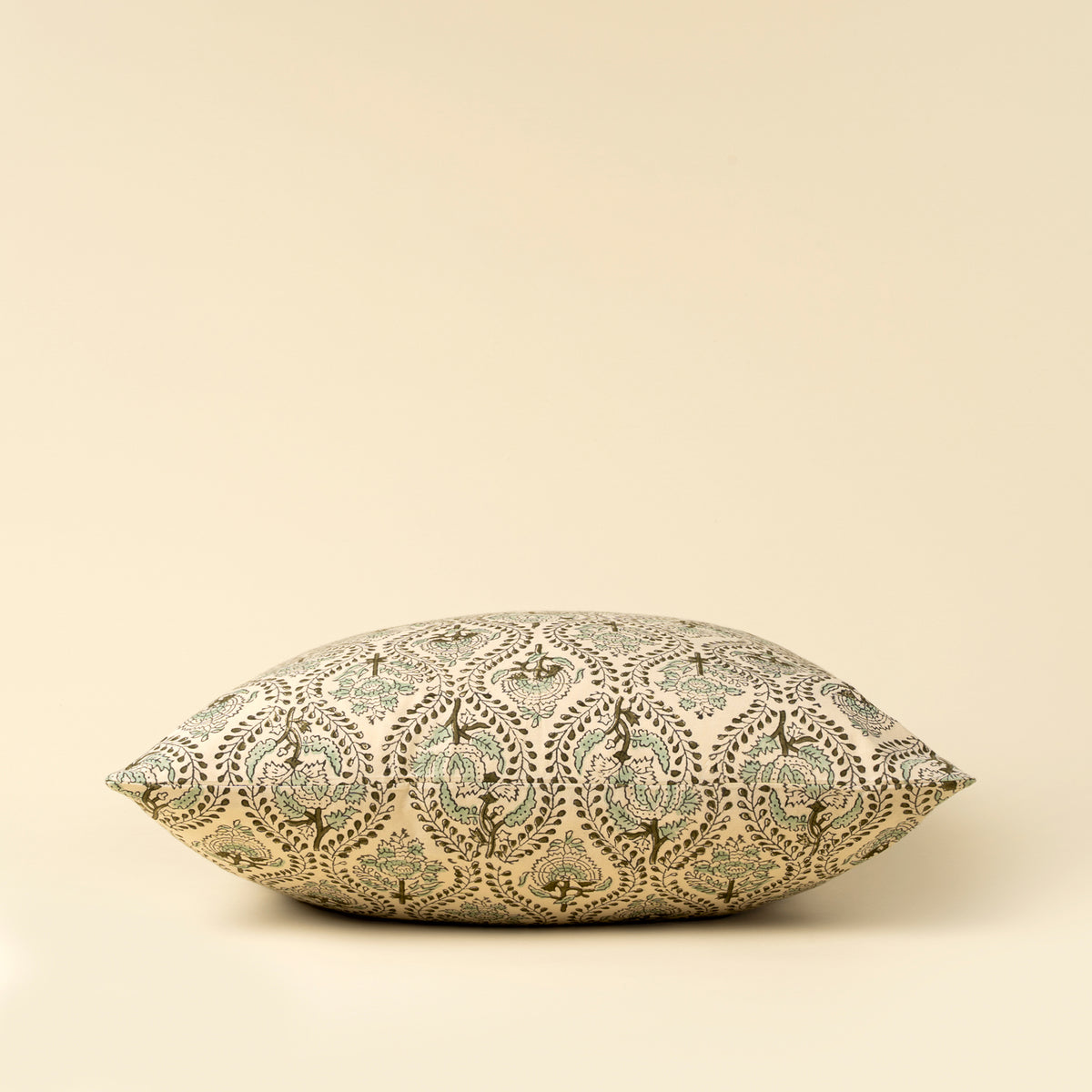 Decorative pillow with intricate pattern on a beige background