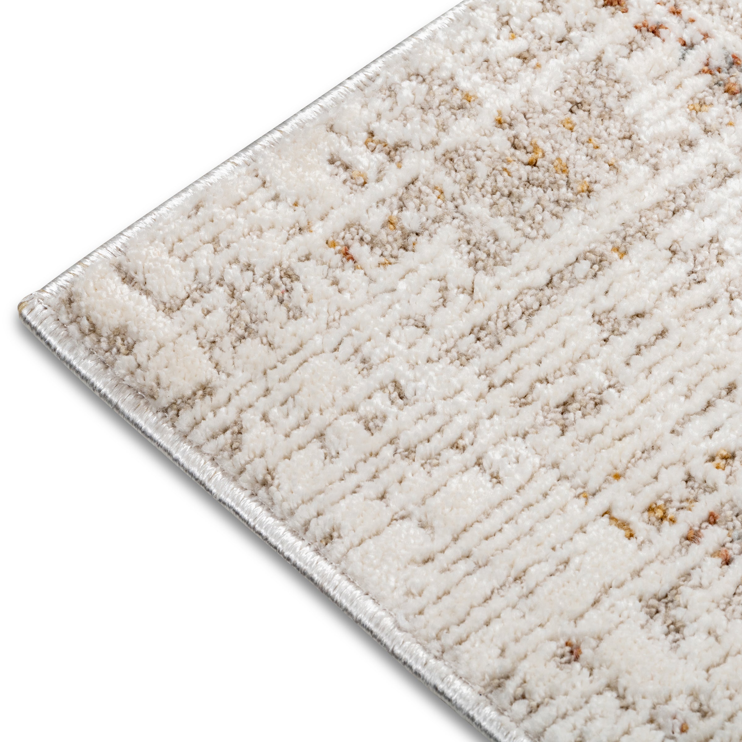Macro detail of the bound edge and soft, plush pile on the neutral and rust Lennox abstract rug.