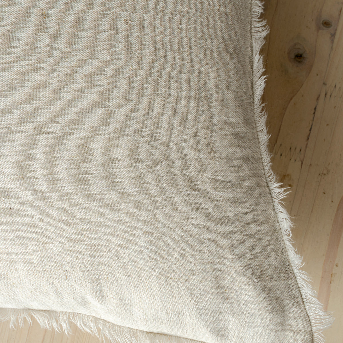 Macro close-up of the Lina linen pillow showcasing the breathable fabric and the delicate frayed fringe edge