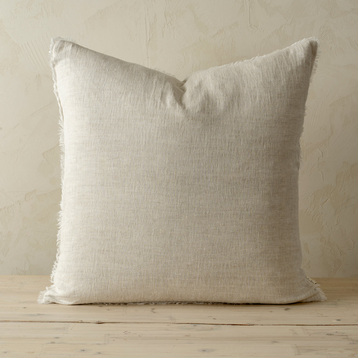 Full front view of the Lina linen pillow featuring a natural raw-edge fringe detail.