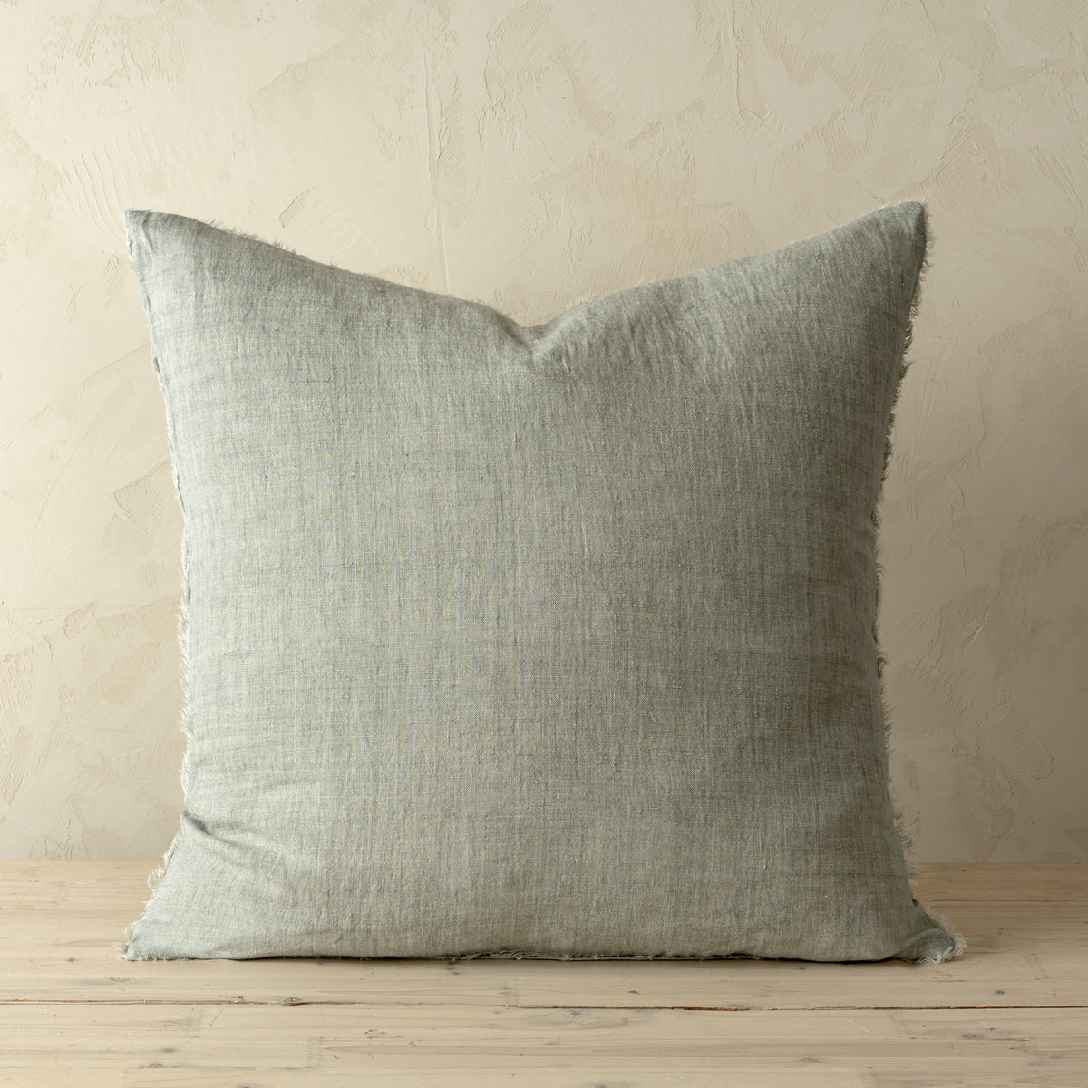 Full front view of the Lina linen pillow featuring a natural raw-edge fringe detail.