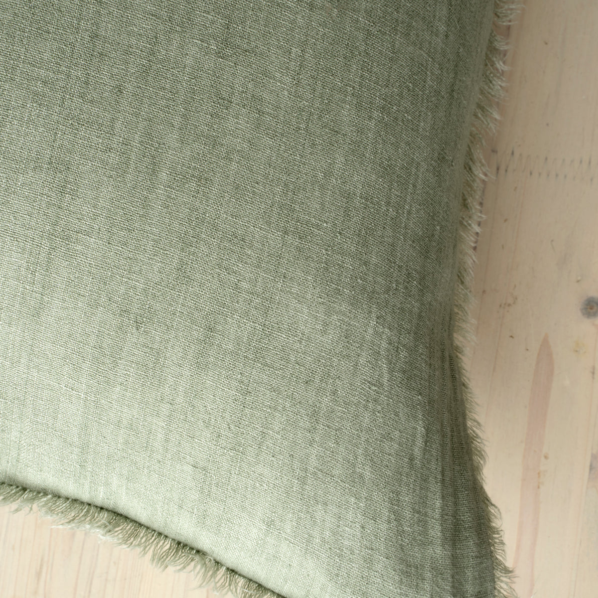 Macro close-up of the Lina linen pillow showcasing the breathable fabric and the delicate frayed fringe edge