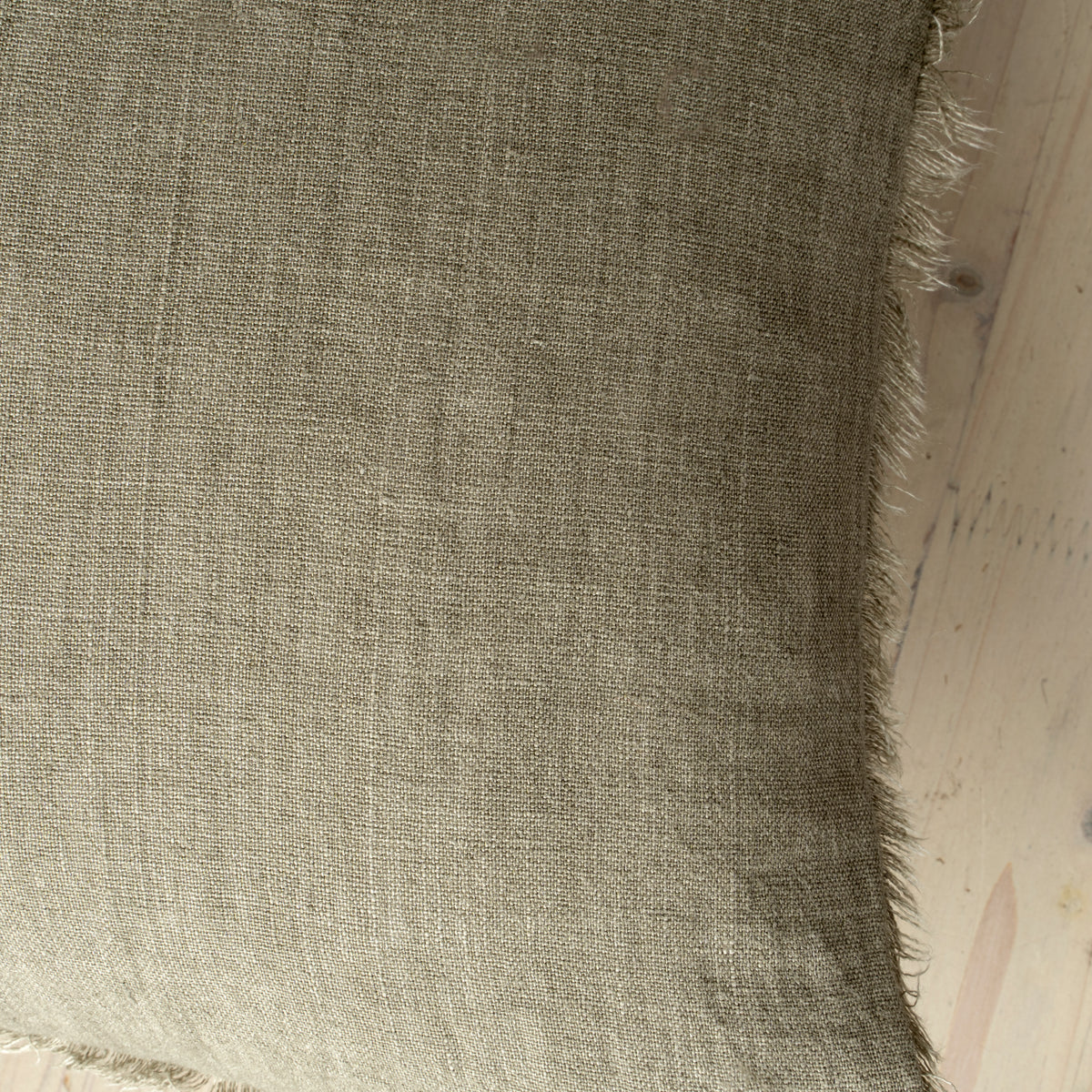 Macro close-up of the Lina linen pillow showcasing the breathable fabric and the delicate frayed fringe edge
